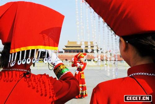 身著(zhù)少數民族服飾的女服務(wù)員在天安門(mén)前合影