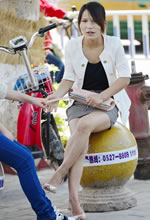 坐在石球上歇息的裸腿